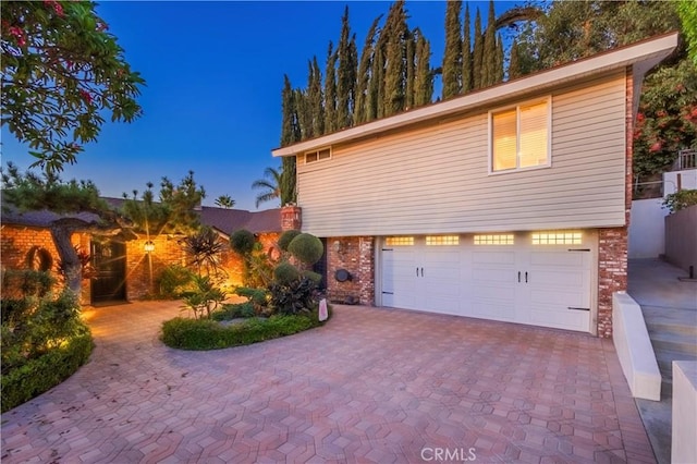2333 N Coronet Ct, Covina, CA 91724 - view of property exterior with a garage, decorative driveway, and brick siding
