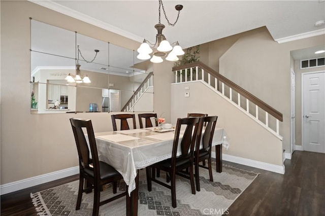 dining space featuring a chandelier, wood finished floors, crown molding, and stairs