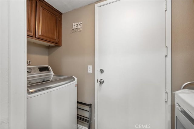 laundry room with cabinet space and washer and clothes dryer