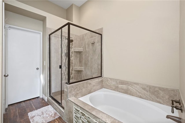 full bathroom featuring a garden tub, wood finished floors, and a stall shower