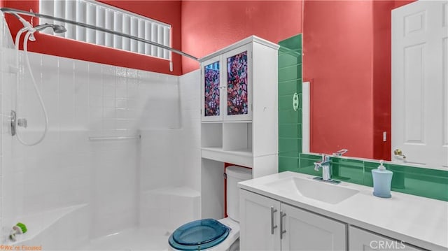 bathroom featuring a shower, vanity, and toilet