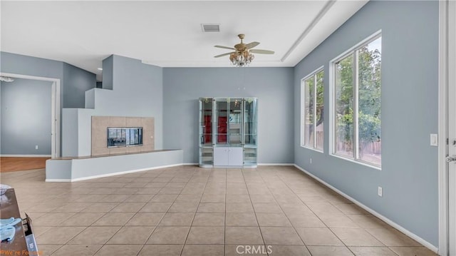 unfurnished living room featuring visible vents, ceiling fan, tile patterned flooring, and baseboards