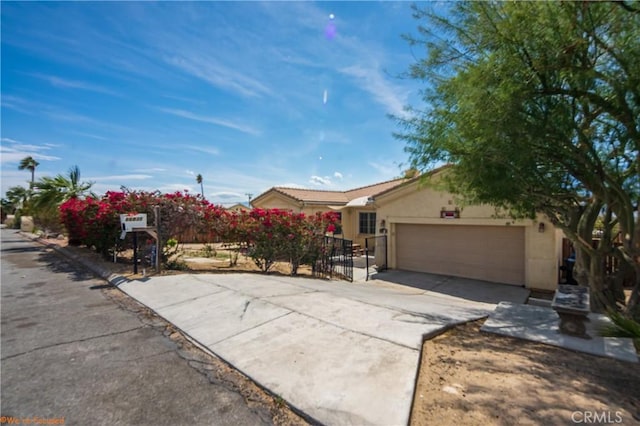 view of front of property with an attached garage, driveway, and stucco siding