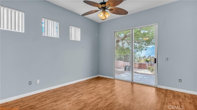 empty room featuring baseboards, a ceiling fan, and wood finished floors