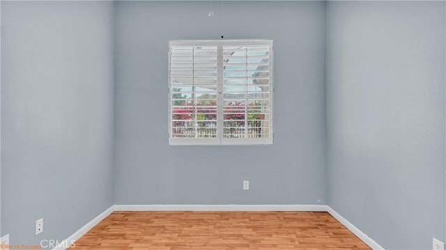 spare room featuring wood finished floors and baseboards
