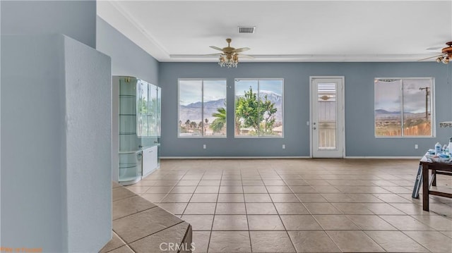 interior space with tile patterned floors, visible vents, baseboards, and ceiling fan