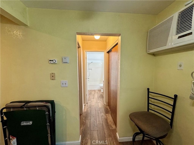 hall featuring baseboards and wood finished floors