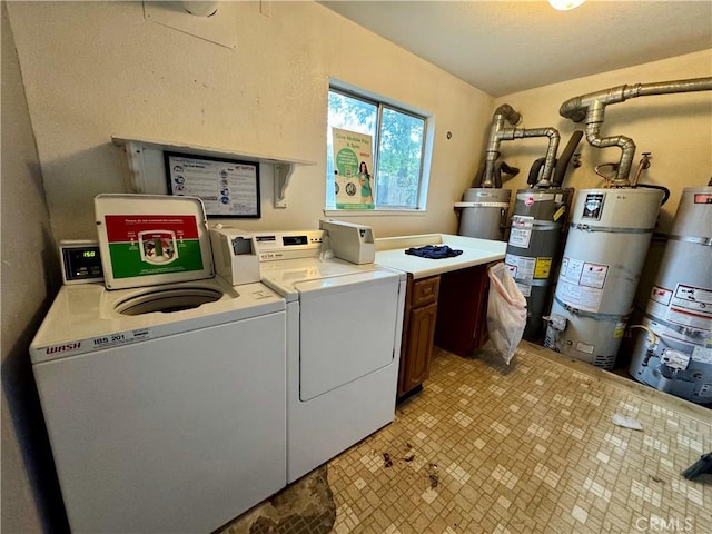 laundry room with washer and dryer, strapped water heater, and cabinet space