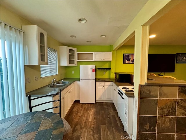 kitchen featuring white cabinets, open shelves, dark countertops, a sink, and white appliances