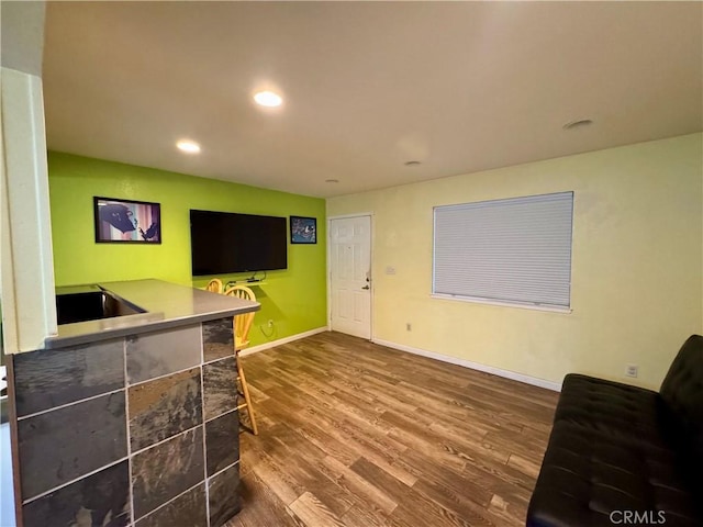 living room with baseboards, wood finished floors, and recessed lighting
