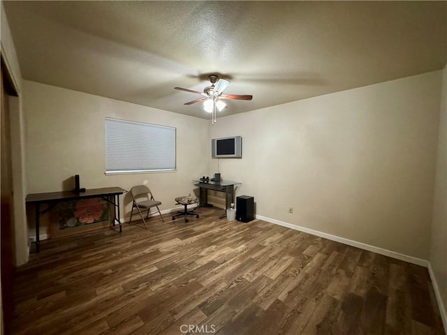 office area with ceiling fan, baseboards, and dark wood-style flooring