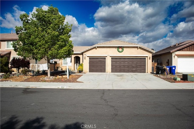 ranch-style house featuring an attached garage, stucco siding, and concrete driveway
