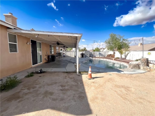 view of swimming pool featuring a ceiling fan, a fenced in pool, a fenced backyard, cooling unit, and a patio area