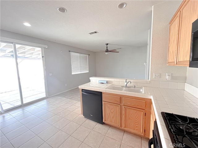 kitchen featuring tile countertops, black appliances, light brown cabinetry, ceiling fan, and visible vents