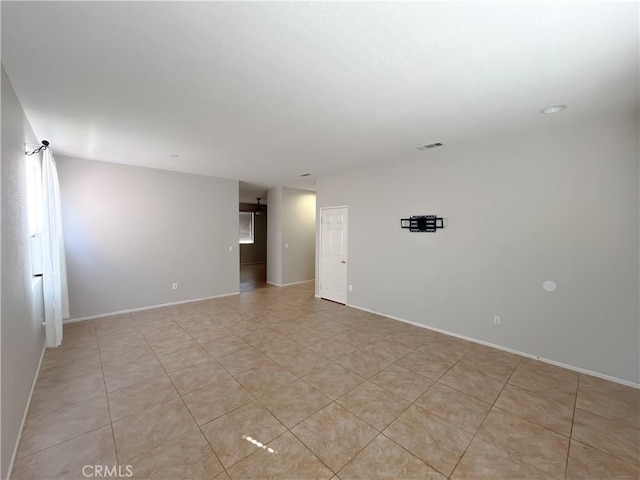 spare room with baseboards and visible vents