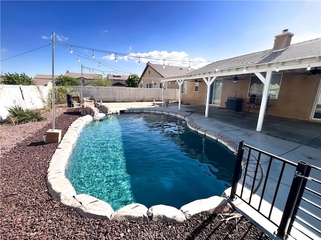 view of swimming pool featuring a fenced in pool, a fenced backyard, central AC, a ceiling fan, and a patio area