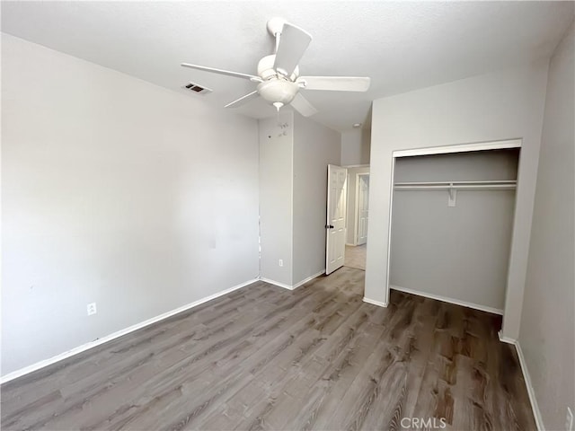 unfurnished bedroom with visible vents, baseboards, wood finished floors, a closet, and ceiling fan