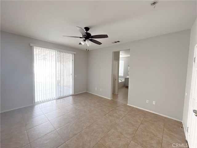 empty room with light tile patterned floors, baseboards, visible vents, and ceiling fan