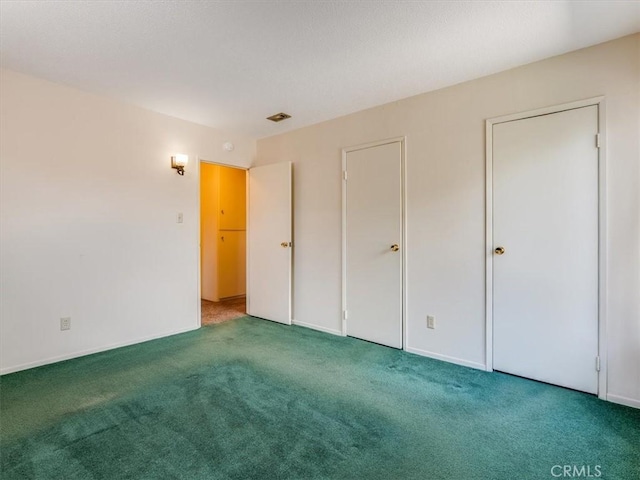 unfurnished bedroom featuring baseboards, visible vents, carpet, and a textured ceiling