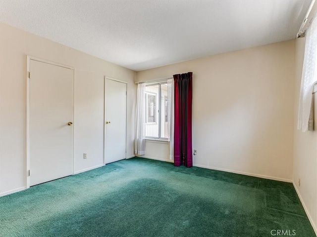 carpeted spare room with baseboards and a textured ceiling