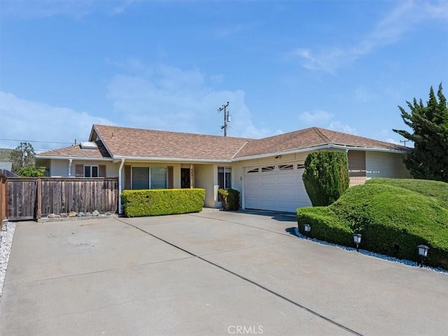 single story home featuring driveway, an attached garage, and fence
