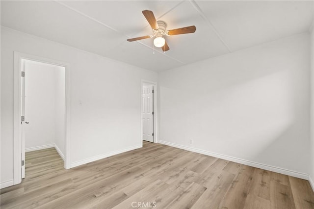 spare room with light wood-type flooring, baseboards, and ceiling fan