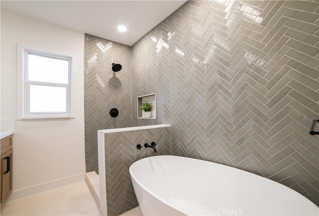 full bath featuring a freestanding bath, vanity, tile patterned flooring, and walk in shower