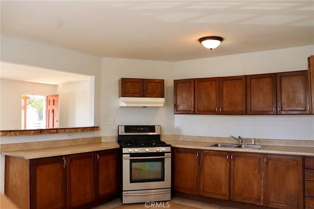16226 Pine St, Hesperia, CA 92345 - kitchen with a peninsula, light countertops, under cabinet range hood, stainless steel range with gas stovetop, and a sink