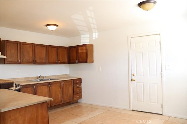 16226 Pine St, Hesperia, CA 92345 - kitchen with brown cabinetry, baseboards, light countertops, and a sink