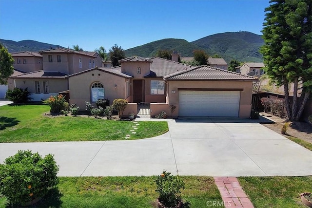 391 Camino Carta, San Marcos, CA 92078 - mediterranean / spanish-style house featuring a mountain view, stucco siding, a tile roof, and a garage