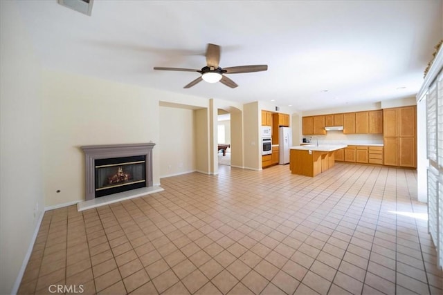 391 Camino Carta, San Marcos, CA 92078 - unfurnished living room with light tile patterned floors, ceiling fan, a glass covered fireplace, and baseboards