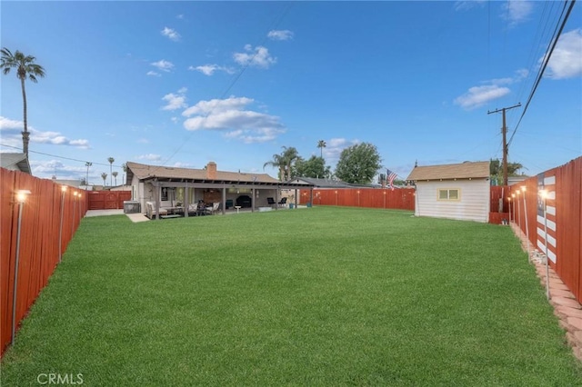 view of yard featuring an outdoor structure and a fenced backyard