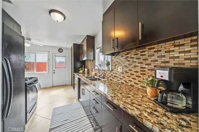 kitchen featuring a sink, backsplash, black appliances, and a wealth of natural light