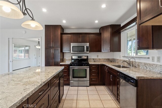 kitchen with a wealth of natural light, dark brown cabinets, stainless steel appliances, and a sink