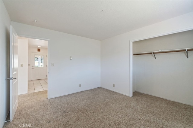 unfurnished bedroom featuring baseboards, a closet, and carpet