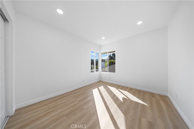 unfurnished room featuring recessed lighting, baseboards, and light wood-style floors