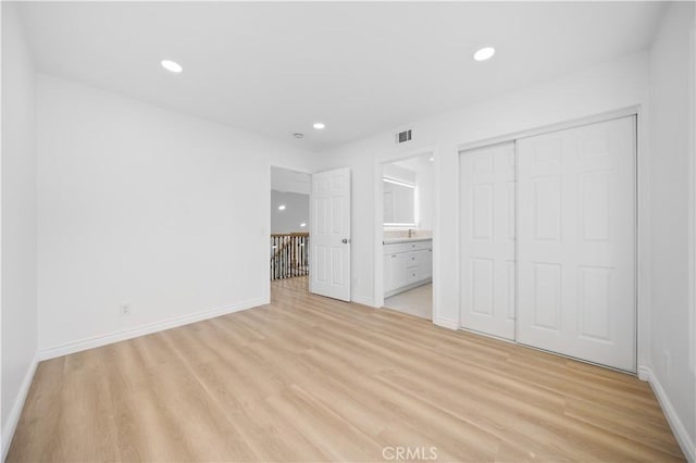 unfurnished bedroom featuring recessed lighting, baseboards, light wood-style flooring, and a closet
