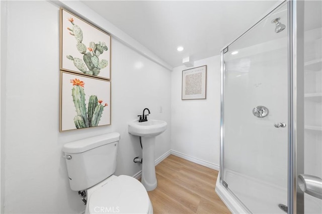 bathroom featuring wood finished floors, toilet, baseboards, recessed lighting, and a stall shower