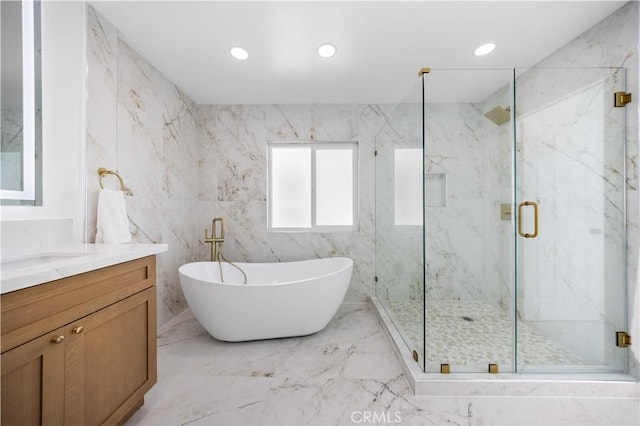 full bath with a freestanding bath, a marble finish shower, marble finish floor, and vanity