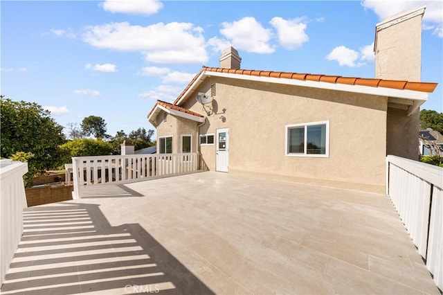24812 Elena Dr, Laguna Hills, CA 92653 - view of property exterior featuring a chimney, stucco siding, a tile roof, and a patio