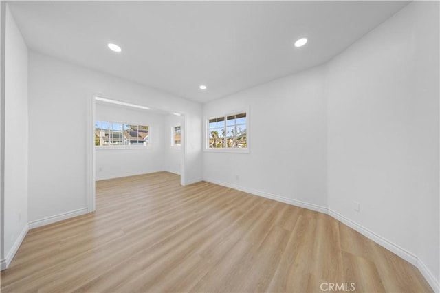 spare room featuring light wood-style floors, recessed lighting, and baseboards
