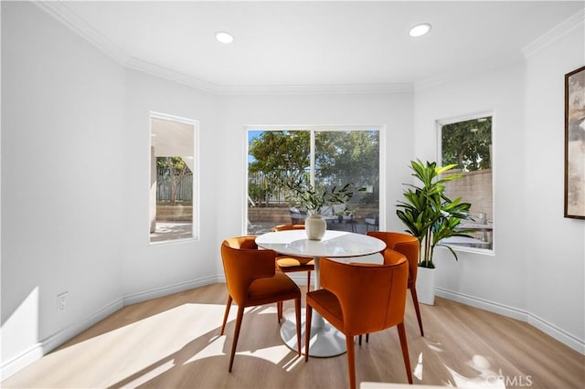 dining room featuring light wood-style floors, baseboards, crown molding, and recessed lighting