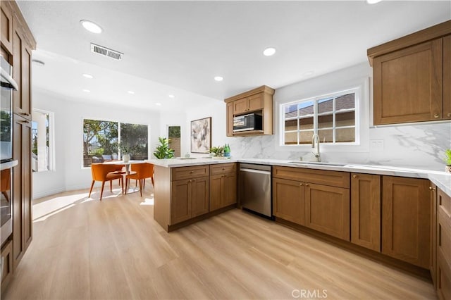 kitchen featuring black microwave, a sink, dishwasher, a peninsula, and recessed lighting