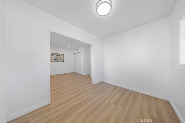 unfurnished room with baseboards and light wood-style floors