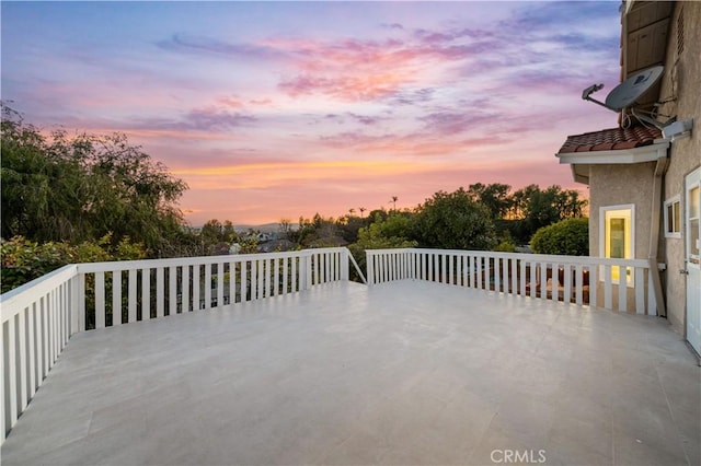 patio terrace at dusk with a deck and outdoor dining space