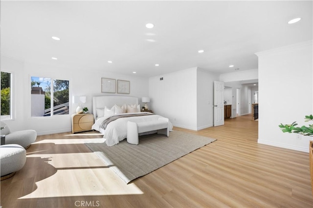 bedroom with recessed lighting, baseboards, crown molding, and light wood-type flooring