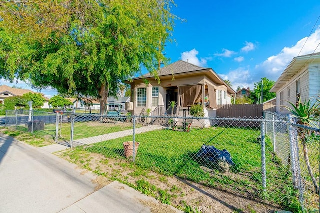 bungalow-style home featuring a gate, a front lawn, and fence private yard