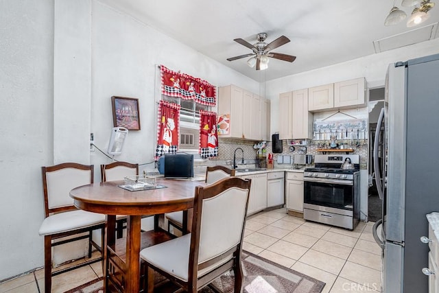kitchen featuring light countertops, a sink, a ceiling fan, tasteful backsplash, and stainless steel appliances