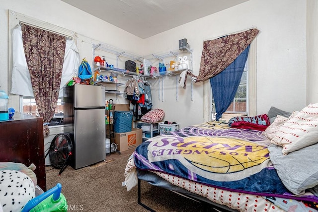 carpeted bedroom with freestanding refrigerator