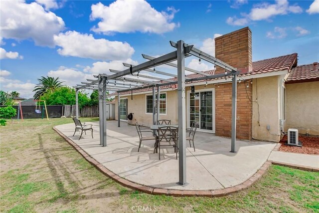 rear view of house with a tile roof, stucco siding, fence, a pergola, and a chimney